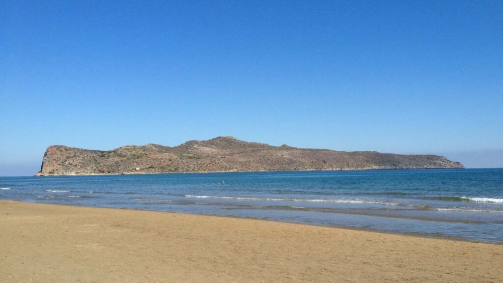 Plage de sable de Chania avec vue sur l'île de Thodorou, destination d'excursion en bateau